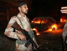 Security personnel stand guard after a blast in a market in Karachi, Pakistan, Dec. 27, 2009. At least 16 people were injured in the blast.(Xinhua/Anwar Aabbas)