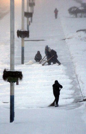 City cleaners clear away snow on a street in Weihai, east China&apos;s Shandong Province, Jan. 13, 2010. [Xinhua]