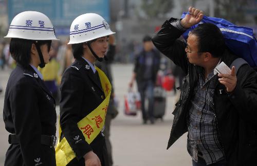 Photo taken on Jan. 30, 2010 shows students from local police school helping railway passengers at the Railway Station in Guangzhou, south China's Guangdong Province. China on Saturday began its annual mass passenger transportation for the traditional Lunar New Year, with an expected 2.54 billion journeys in the coming 40 days. 