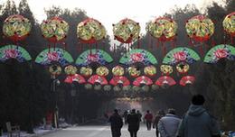 Visitors promenade inside the Ditan (Altar of the Earth) Park with colorful festival adornments, as the festival atmosphere for the 25th Spring Festival Temple Fair slated from February 13 to 20, at Ditan Park is drumming up, in Beijing, February 4, 2010. 