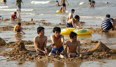 People amuse themselves on the beach in Haikou, capital of south China's Hainan Province, Feb. 10, 2010. According to local weather report, the highest temperature in the province has reached 35 degrees Celsius on Wednesday. A large number of people in Haikou went to the beach to cool themselves down.