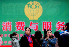 Consumers walk by the billboards of 3.15 World Consumer Rights Day in Shenyang, Northeast China's Liaoning Province, on March 14, 2010. The theme this year is 'consumption and service'. [CFP Photo]