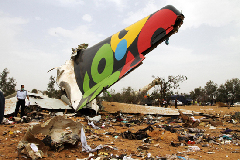 Rescue workers examine the debris of the crashed plane at the spot in Libyan capital of Tripoli, May 12, 2010. Afriqiyah Airways said in a statement there were 93 passengers and 11 crews aboard the plane, which crashed at Tripoli airport early Wednesday morning.[Xinhua photo]