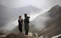 Afghan security personnel are on standby near the mountains where an Afghan Pamir Airways plane is believed to have crashed in the Salang pass May 17, 2010.