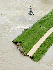 A helicopter drops sand bags to reinforce an already destroyed flood embankment near the village of Swiniary in Central Poland May 24, 2010. [Xinhua/Reuters]