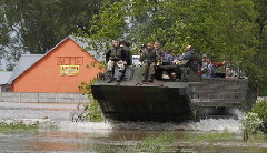 An amphibious vehicle transports people from the flooded village of Juliszew May 24, 2010.[China Daily/Agencies]