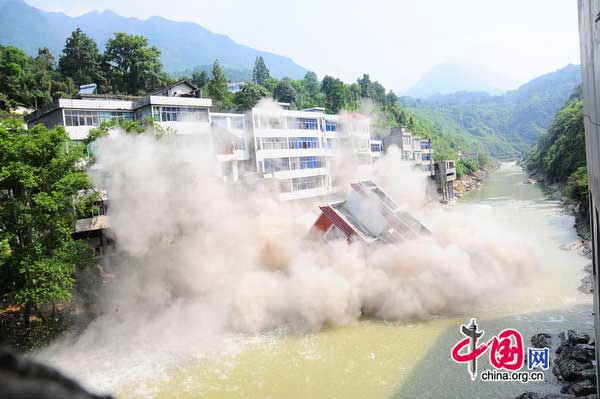 A seven-story illegal building is demolished by a blast along a river in Hefeng County, Central China&apos;s Hubei province on July 29, 2010. [CFP] 