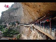 The Sky Bridge area, the next stop through the mountain, features a path built into the wall of the cliff and a temple below.  [Photo by Courtney]