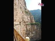 A sign on the road through Mianshan points to the 'Cliff of Fear,' which is also known as “Sacrifice Cliff.” Like the Sky Bridge, the walkway of the Cliff of Fear is built right into the cliff of the mountain, and the path offers a great view of the valley below. [Photo by Courtney]