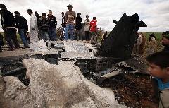 People look at a U.S Air Force F-15E fighter jet after it crashed near the eastern city of Benghazi March 22, 2011. The fighter jet crashed in Libya overnight after apparent mechanical failure but its crew were safe, a spokesman for the U.S. military Africa Command said on Tuesday. [Xinhua]