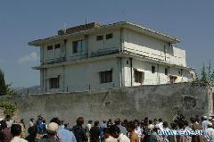 Media personnels and local residents gather outside the compound where Osama bin Laden had been living for years in Abbottabad, a main city in Pakistan's northwestern Khyber Pakhtunkhwa province, on May 3, 2011. 