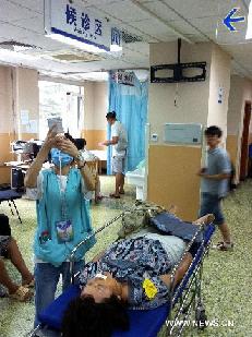 A wounded woman receives medical treatment at the Peking University People's Hospital after an accident happened in the Beijing Zoo Station of Subway Line 4 in downtown Beijing, capital of China, July 5, 2011.