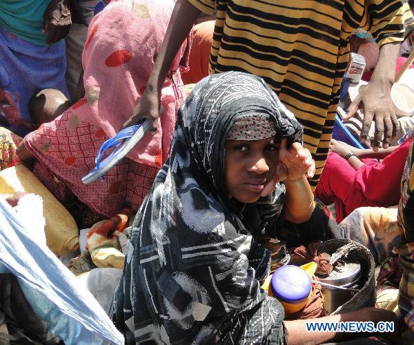 People leave homes for a new camp due to drought in the southwestern outskirts of Mogadishu, capital of Somalia, July 12, 2011. Hundreds of people arrived in government-controlled Mogadishu each day to seek food and shelter. [Faisal Isse/Xinhua] 