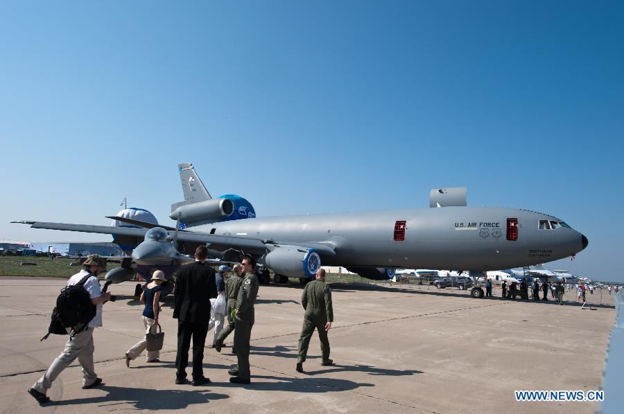 Visitors walk past the airplanes on the Tenth Russia National Aerospace Exhibition in Moscow, Russia on Aug. 16, 2011. The Exhibition will last for six days, and 793 companies from 40 nations and regions participated. [Jiang Kehong/Xinhua] 