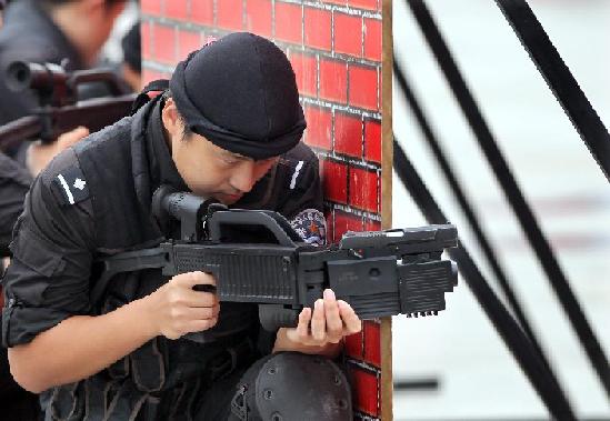 A special policeman uses a corner shot to aim at objects during an anti-terror drill in Shanghai, Sept 14, 2011. [Photo/Xinhua]