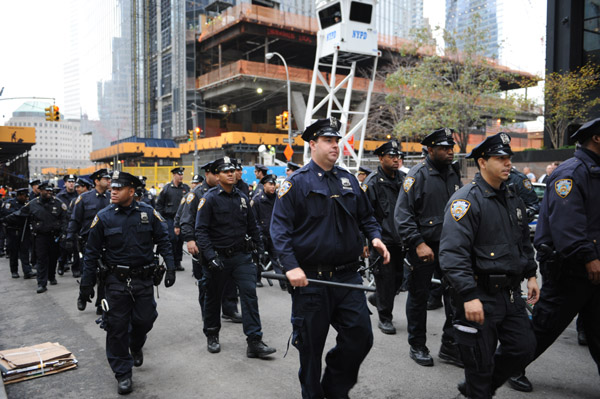 Police stand guard as Occupy Wall Street protesters demonstrate near Zuccotti Park in New York City, the United States, Nov. 15, 2011. New York police cleared up Zuccotti Park early Tuesday after Occupy Wall Street protesters encamped for two months, and arrested around 200 protesters for resisting orders. [Deng Jian/Xinhua]