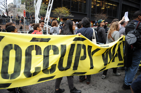 Occupy Wall Street protesters demonstrate near Zuccotti Park in New York City, the United States, Nov. 15, 2011. New York police cleared up Zuccotti Park early Tuesday after Occupy Wall Street protesters encamped for two months, and arrested around 200 protesters for resisting orders. [Deng Jian/Xinhua]