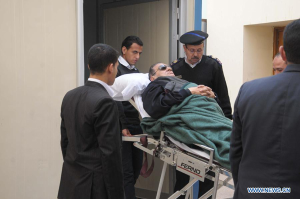 Egypt's ex-President Hosni Mubarak (C) is wheeled on a hospital stretcher into court for the resumption of his trial in Cairo, Egypt, Jan. 2, 2012, as his trial resumed. The trials of Egypt's ex-President Hosni Mubarak, his sons, former Interior Minister Habib el-Adli as well as Adli's six assistants resumed on Monday.