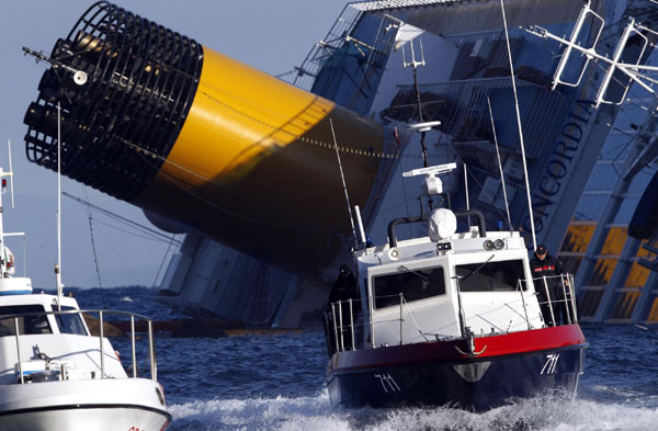 A boat with rescue workers is seen near the Costa Concordia cruise ship that ran aground off the west coast of Italy, at Giglio island January 17, 2012. [Photo/Agencies]